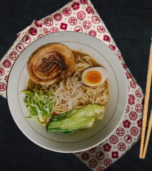真上から見た豚骨ラーメン。炙りチャーシュー、味玉、青菜。